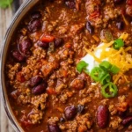 Healthy stovetop turkey chili in a bowl garnished with fresh herbs.