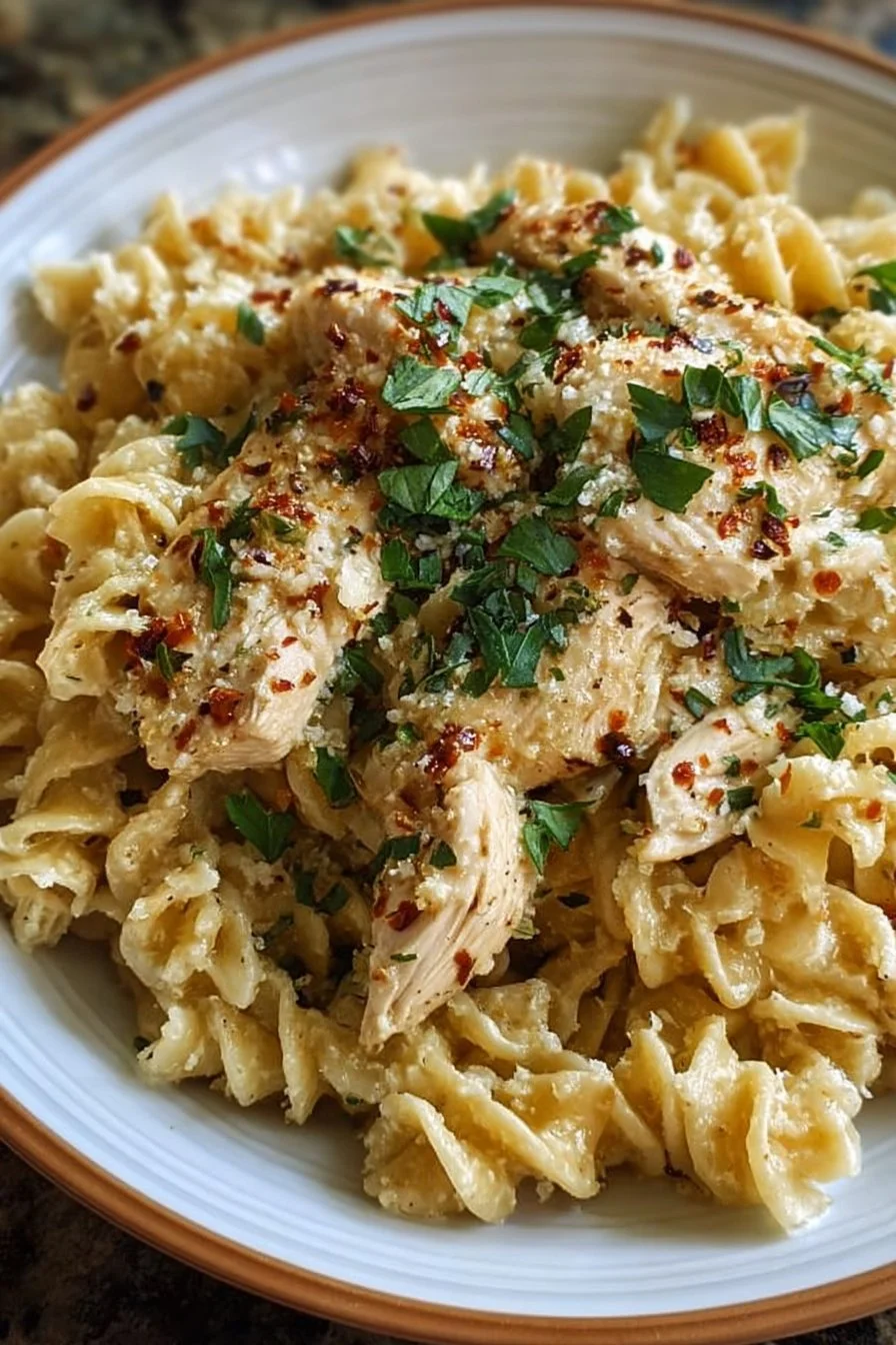 Plate of creamy Garlic Parmesan Chicken Pasta with a sprinkle of parsley.