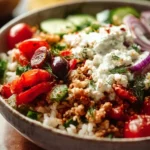 A bowl of Greek Turkey Rice with fresh vegetables and herbs