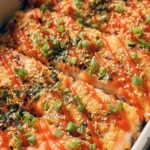 Deliciously baked Salmon Sushi Bake served in a casserole dish with toppings.